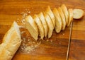French crisp fresh baguette with a golden crust or a long loaf baked in a bakery and cut into slices on a wooden board