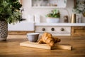 french croissants and cup with coffee on wooden cutting board at kitchen Royalty Free Stock Photo