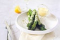 French cuisine. Fresh green asparagus with hollandaise sauce and glass of white wine Royalty Free Stock Photo