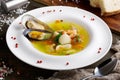 French seafood soup with white fish, shrimps and mussels in plate at wooden background Royalty Free Stock Photo