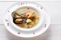 French seafood soup with white fish, shrimps and mussels in plate at wooden background Royalty Free Stock Photo