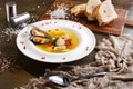 French seafood soup with white fish, shrimps and mussels in plate at wooden background Royalty Free Stock Photo