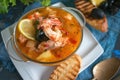 French fish soup Bouillabaisse with seafood, salmon fillet, shrimp, rich flavor, delicious dinner in a white beautiful Royalty Free Stock Photo