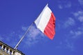 French flag waving in front of facade of city hall waving in blue sky of france