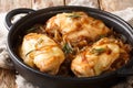 French food chicken onion fillet with cheese and spicy wine sauce close-up in a pan on the table. horizontal