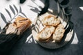 French fresh bread baguette with slices on a ceramic plate on gray background. Royalty Free Stock Photo