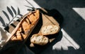 French fresh bread baguette with slices on a ceramic plate on gray background. Royalty Free Stock Photo