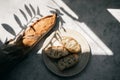 French fresh bread baguette with slices on a ceramic plate on gray background. Royalty Free Stock Photo