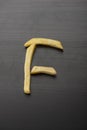 French fries Alphabet F on wooden background