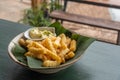 French fries on banana leaf and ceramic bowl with mayo sauce