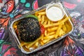 French fries and black burger. Royalty Free Stock Photo