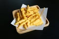 French fries cheese on black table background