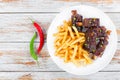 French fries with fried sticky ribs, top view Royalty Free Stock Photo