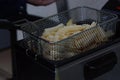 French fries in the fryer, ready to be plunged in oil