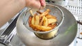 French fries in grid basket, My hand to hanging all for drying Royalty Free Stock Photo