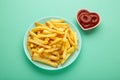 French fries with ketchup in bowl on mint background Royalty Free Stock Photo