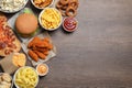 French fries, onion rings and other fast food on wooden table, flat lay with space for text Royalty Free Stock Photo