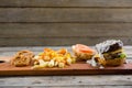 French fries with sauce by burger and onion rings on cutting board Royalty Free Stock Photo