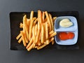 french fries with sauce and mayonnaise on black background. top view Royalty Free Stock Photo