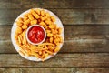 French fries and tasti taters with ketchup on wooden table