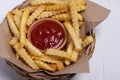 French fries and tomato sauce in a wicker basket Royalty Free Stock Photo