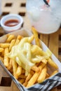 French Fries on Toping Cheese in Paper Box.