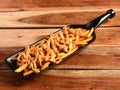 French fries topped with masala flavored cheese, served in a plate over a rustic wooden background, selective focus Royalty Free Stock Photo