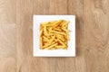 French fries - white plate square - wooden background Royalty Free Stock Photo