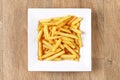 French fries - white plate square - wooden background Royalty Free Stock Photo