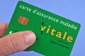 French health insurance card in hand on blue background