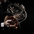 French horn player hands playing brass instrument