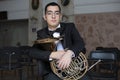 French horn player. Hornist playing brass orchestra music instrument.