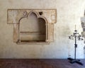 French limestone 13th century lavabo and wrought iron candelabara with candle in the Cloisters in New York City.