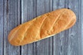 French loaf on rustic wood background flat lay
