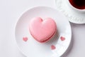 French macaron heart shaped Valentine gift. Romantic date coffee dessert cookie confection. Light pink macaroni close up