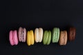 French macaroon cookies on black isolated background