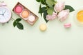 French macaroons. Many variegated sweet macarons in box with bouquet of pink roses on the table Royalty Free Stock Photo