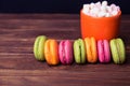 French macaroons and marshmellow in dark wooden background