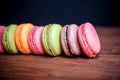 French macaroons and marshmellow in dark wooden background