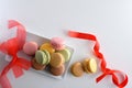 French macaroons with red bow on white table top view