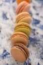 French macaroons in a row colored, on a colored background. Vertical frame Royalty Free Stock Photo