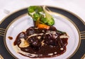 French dish of beef bourguignon on a golden rim dinner plate. Royalty Free Stock Photo