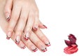 French manicure - beautiful manicured female hands with red black and white manicure with rhinestones isolated on white background Royalty Free Stock Photo