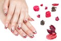 French manicure - beautiful manicured female hands with red black and white manicure with rhinestones isolated on white background Royalty Free Stock Photo