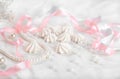 French meringue cookies for wedding background with pearls, pink and white satin ribbons and lace