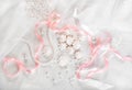 French meringue cookies for wedding background with pearls, pink and white satin ribbons and lace, flat lay