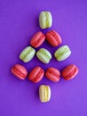 French green red macarons shaped as Christmas tree on purple background. Top view