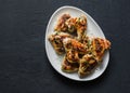 French mustard marinade roasted chicken wings - delicious appetizers, tapas on dark background, top view