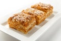 French Napoleon Cake of puff pastry with sour cream on a white plate close-up. Nutritious dessert. Selected Focus Royalty Free Stock Photo