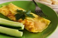 French omelet with cucumbers on a green plate